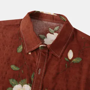 Primo piano del colletto di una camicia a fiori da uomo con cuciture bianche su tessuto rosso