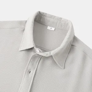Close-up of light gray men's casual shirt featuring a detailed waffle knit texture and collar