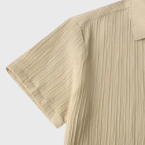 Primer plano de camisa beige de manga corta para hombre con tejido texturizado y cuello solapa