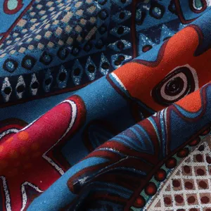 Close-up of vibrant tribal patterns and textured fabric on a men's Hawaiian shirt.