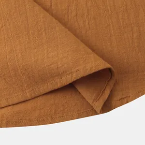 Close-up of mustard brown cotton linen shirt showing textured fabric and stitching