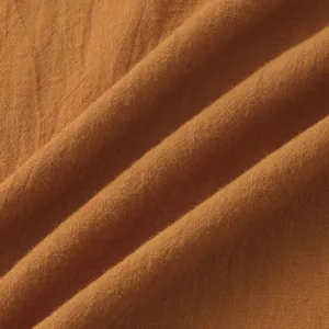 Close-up of breathable cotton-linen fabric texture in burnt orange color