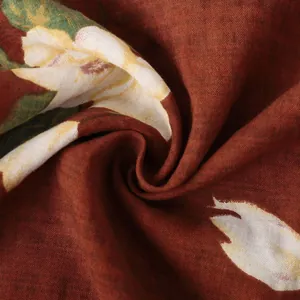Dettaglio del tessuto stampato a fiori rosso ruggine che mostra la trama della camicia