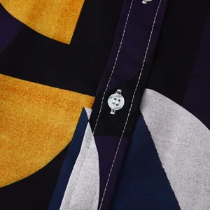 Macro view of a white button and vibrant geometric pattern on a premium men's beach shirt