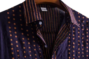 Close-up detail of men's casual shirt with polka dot and stripe patterns on neckline