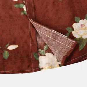 Vista macro delle cuciture bianche e della trama floreale su una camicia marrone effetto lino