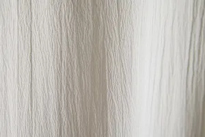 Detailed macro view of white breathable textured fabric for men's summer casual shirts.