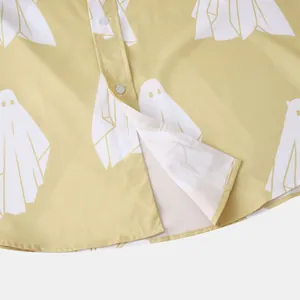 Dettaglio di camicia gialla da uomo con motivo a fantasmi bianchi e orlo arrotondato