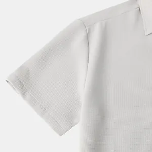 Close-up of men's short-sleeved shirt showing breathable gray waffle knit fabric texture.
