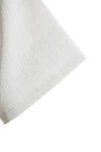 Macro view of white textured fabric and sleeve stitching on minimalist men's summer shirt