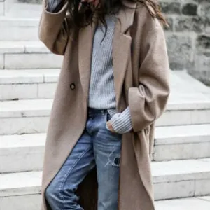 Gedetailleerd zicht op een gezellige oversized kameelwollen jas met grijs gebreid vest