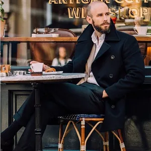 Men's British style navy blue mid-length woolen pea coat in outdoor cafe setting