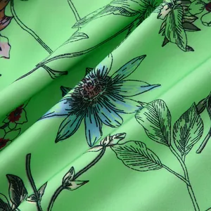 Nahaufnahme der leuchtend grünen floralen Stoffstruktur mit blauen und violetten Blumen