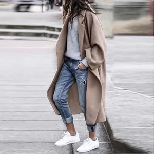 Streetstyle-weergave van een vrouw in een camelkleurige wollen jas en witte sneakers