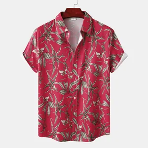 Detailed view of red short sleeve shirt with tropical leaf and flower print pattern.