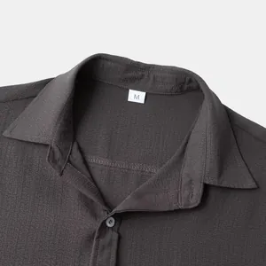 Detailed close-up of a men's dark grey solid shirt collar with textured fabric finish