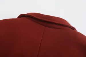 Close-up of the collar and thick wool fabric texture of a burgundy men's overcoat.