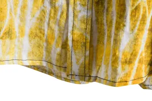 Detailed close-up of yellow tie-dye fabric texture and stitching on a men's casual shirt