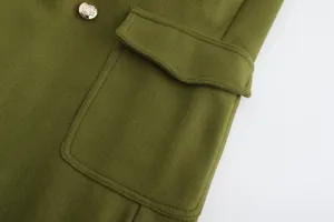 Dettaglio ravvicinato di un cappotto di lana verde oliva con tasca e bottone dorato