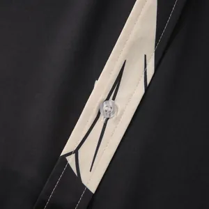 Dettaglio della camicia a maniche corte da uomo con stampa geometrica e bottone chiaro