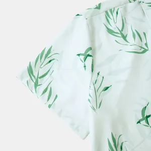 Gros plan sur le motif de feuilles tropicales d'une manche de chemise hawaïenne blanche