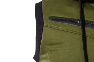 Détail du gilet homme vert armée montrant la poche zippée noire et le bord-côte