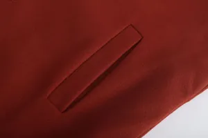 Macro view showing the detailed pocket stitching on a premium burgundy men's woolen overcoat