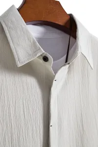 Close-up view of beige textured seersucker fabric on a men's casual short sleeve shirt.