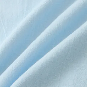 Close-up detail of light blue breathable cotton-linen fabric texture for men's summer shirt