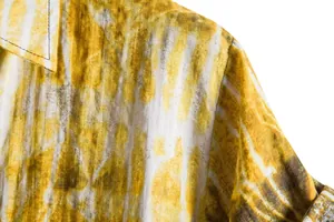 Macro view showing close-up detail of yellow and white tie-dye patterned men's casual shirt fabric