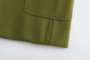 Dettaglio macro del tessuto di lana verde e cuciture delle tasche su cappotto uomo.