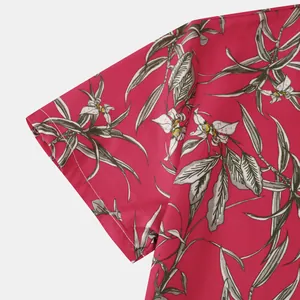 Close-up of tropical floral print and sleeve stitching on pink men's beach shirt.