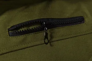 Gros plan détaillé de la fermeture éclair noire sur un gilet de sport vert olive.