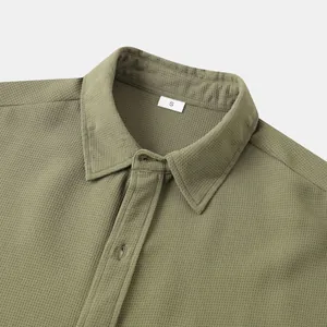 Detailed close-up view of the green waffle knit texture on a men's casual button-down shirt