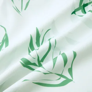 Détail de tissu blanc doux avec motif de feuilles tropicales vert vif en gros plan