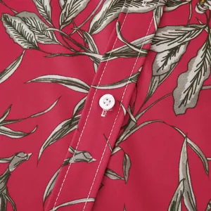 Close-up of white buttons and white stitching on a red floral men's holiday beach shirt