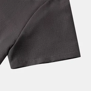 Detail showing the high-quality textured fabric of a men's charcoal grey short-sleeved shirt
