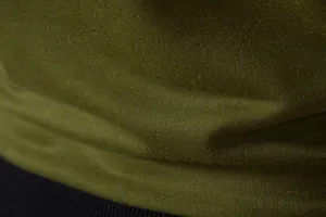 Vue macro du tissu tricoté respirant vert armée sur un gilet de sport pour homme