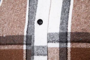Primer plano de la textura de franela cepillada de una camisa de cuadros marrón para hombre