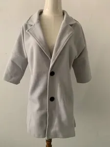 Vue détaillée d'un manteau en laine gris pour femme avec manches 3/4 et revers.