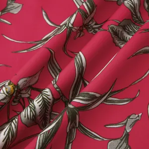 Close-up detail of the vibrant floral print and fabric texture of a beach shirt