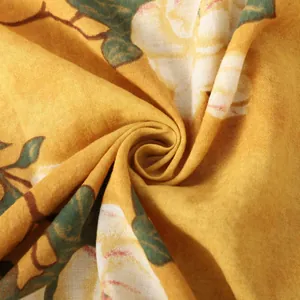 Dettaglio macro del tessuto giallo a fiori traspirante per camicia estiva da uomo