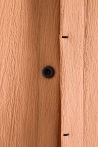 Close-up detail showing the high-quality textured fabric and button on apricot men's shirt
