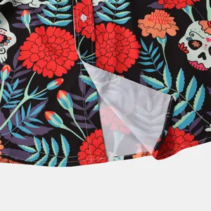 Close-up of Halloween shirt hem showing vibrant sugar skull and marigold floral print details.