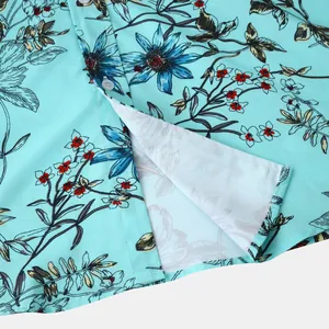 Detailansicht von floralem Druck und Nähten auf einem hellblauen Herren-Kurzarm-Freizeithemden.