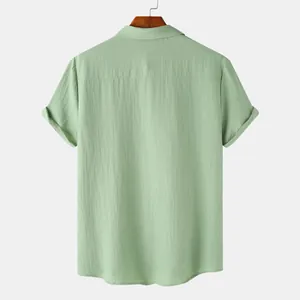Back view of a professional sage green textured short-sleeve shirt hanging on a hanger