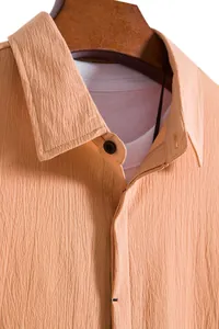 Close-up of men's summer short-sleeved shirt with textured crinkle fabric in peach color