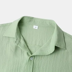 Close-up of green men's shirt collar with textured fabric and size M tag