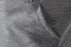 Vue macro détaillée de la poche et des coutures renforcées d'un gilet de sport gris