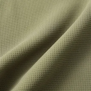 Close-up macro detail of olive green waffle weave fabric for men's summer shirts